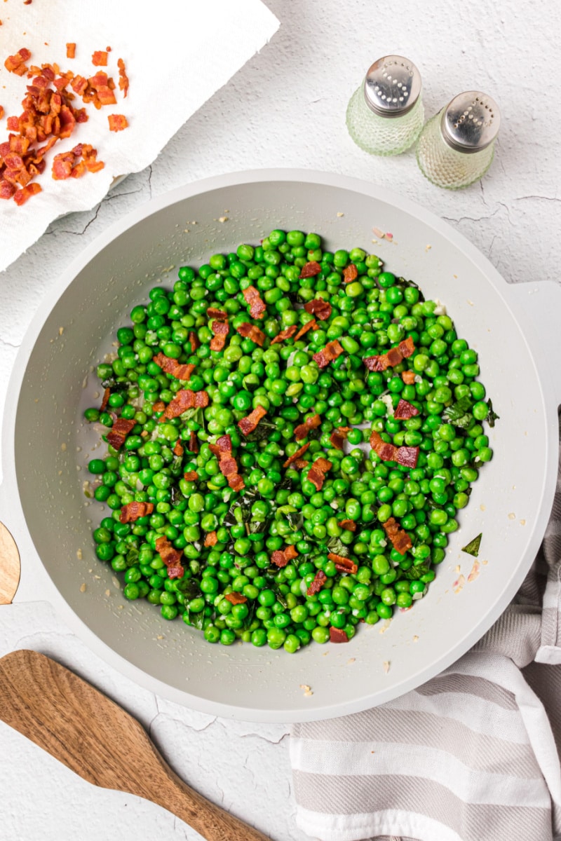 sauteed peas with basil and bacon in a skillet