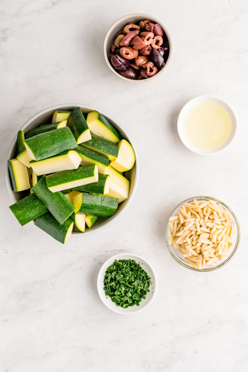 ingredients displayed for making sauteed zucchini with almonds and olives