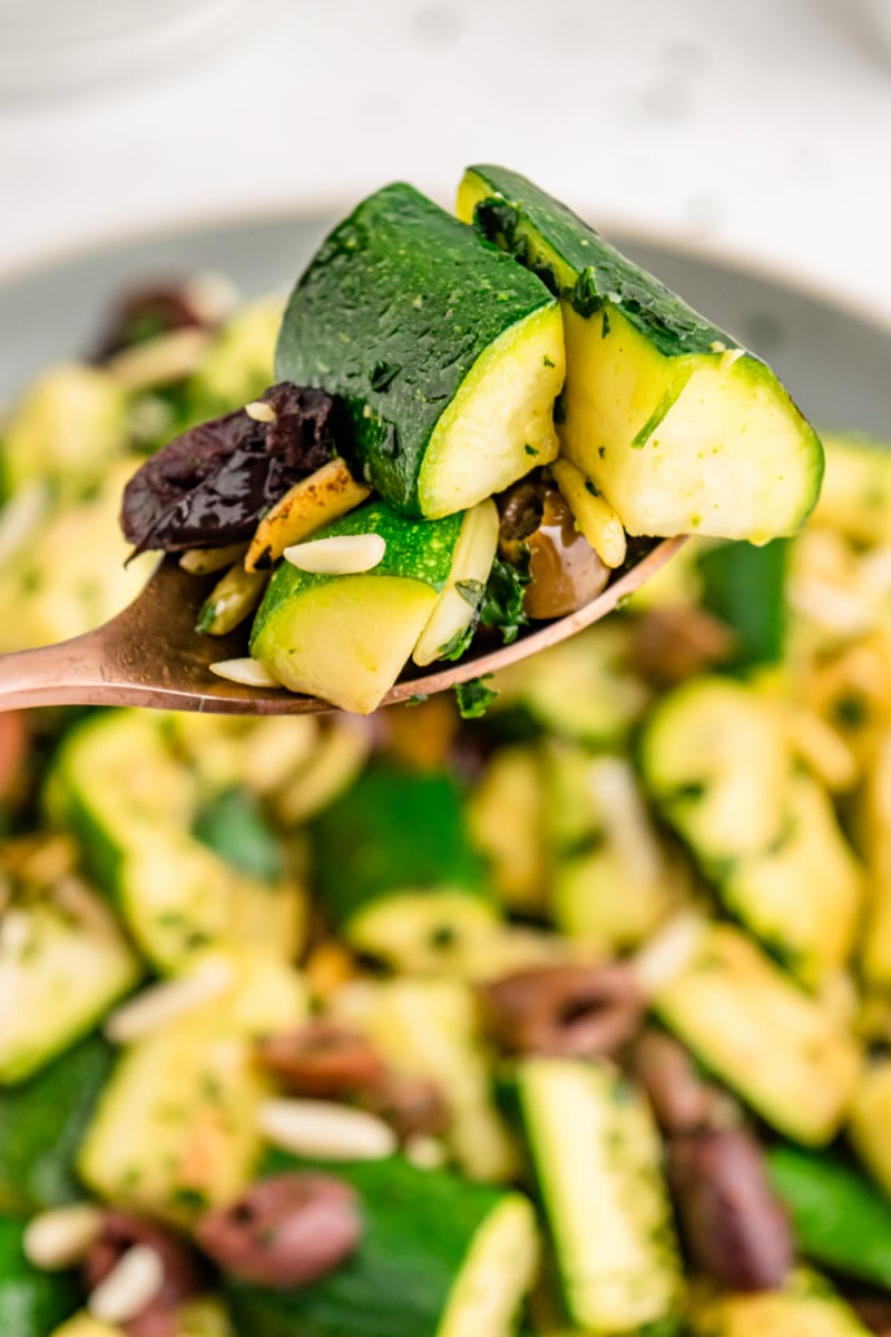 spoonful of sauteed zucchini with almonds and olives