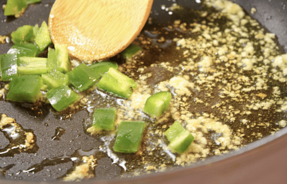 frying peppers and garlic in pan