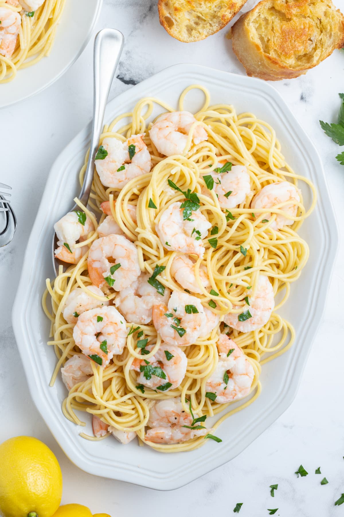shrimp scampi on a platter over pasta