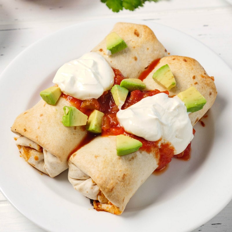 Skinny Chimichangas topped with salsa, sour cream and avocado