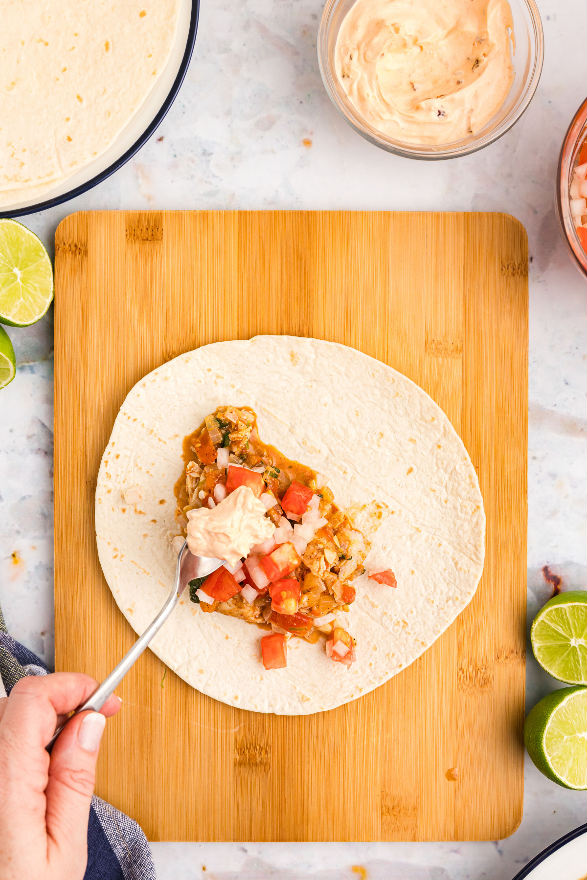 spooning filling into tortilla for taco