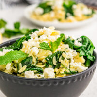 spinach with orzo and feta in a bowl