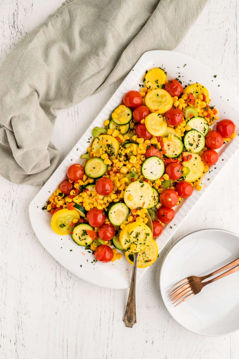 summer squash with cherry tomatoes on white platter