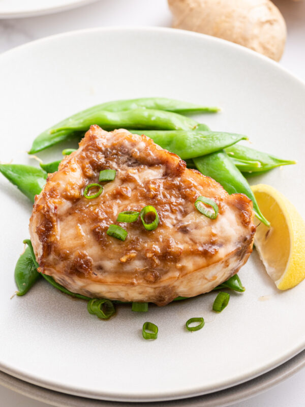 swordfish teriyaki on plate with peas and lemon