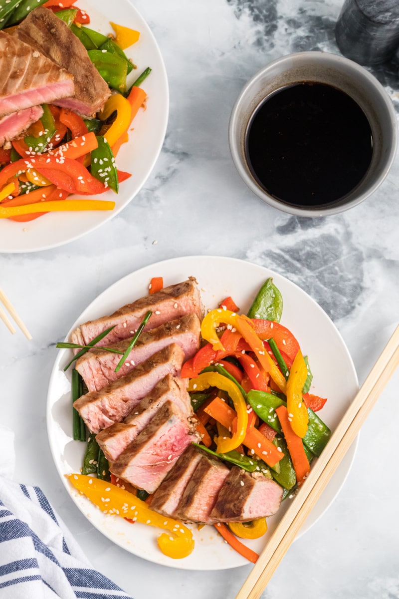 sliced teriyaki tuna on a plate with veggies