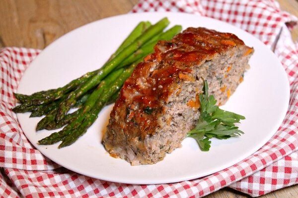 slice of turkey meatloaf on a plate with asparagus