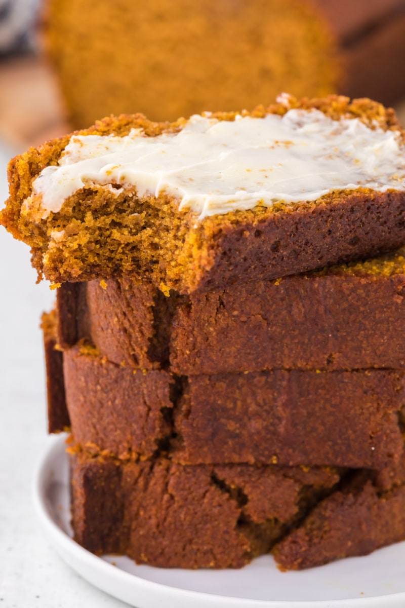 slices of pumpkin bread stacked with butter on top piece