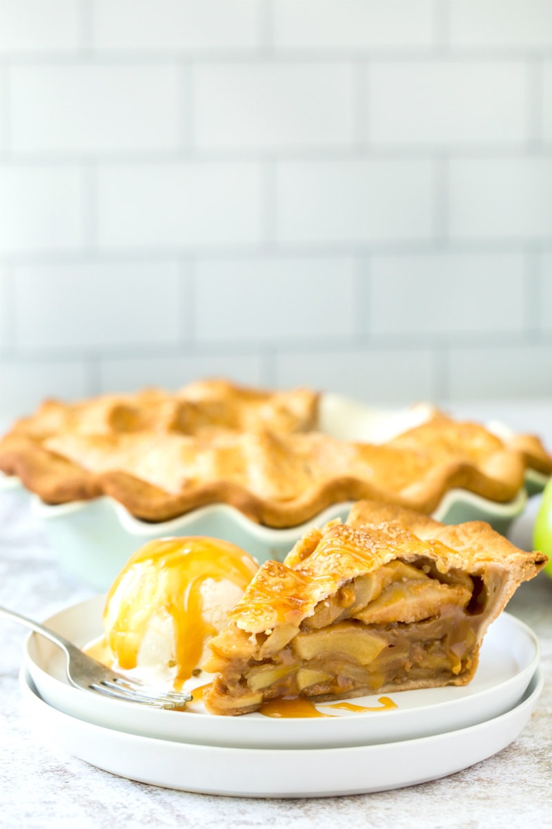 slice of dulce de leche apple pie on white plate with ice cream