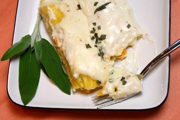 Pumpkin Manicotti with Bechamel Sauce and Fresh Sage on a white plate