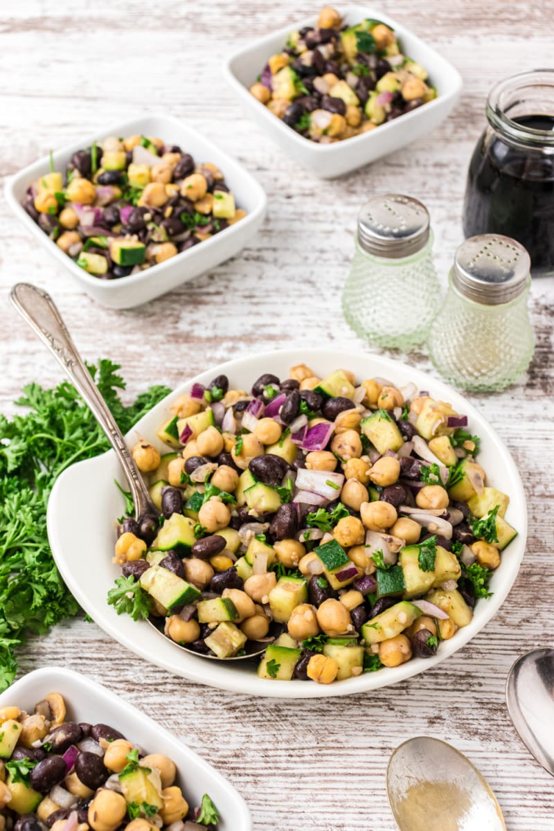 two bean salad in a bowl and then two individual servings in bowls