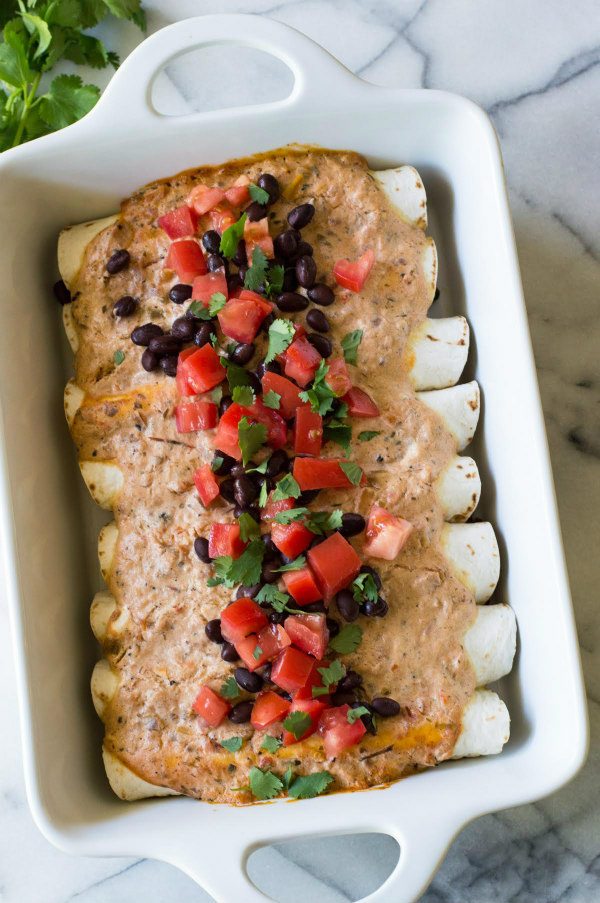 Easy Black Bean Enchiladas recipe from RecipeGirl.com #easy #blackbeans #enchiladas #recipe #RecipeGirl Easy Black Bean Enchiladas in a white casserole dish