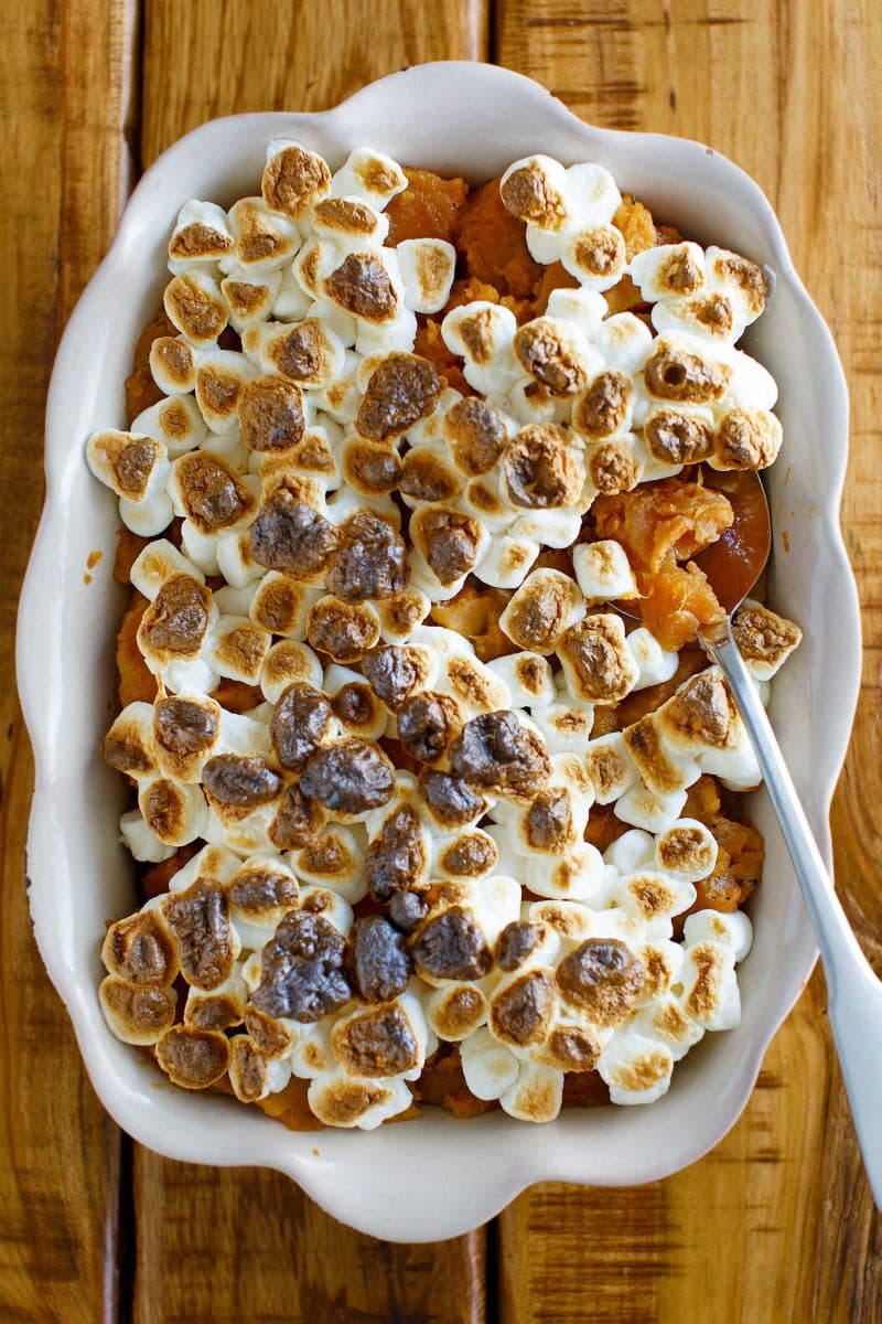 casserole dish of glazed sweet potatoes with toasted marshmallows