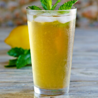 Sweet Summer Iced Tea garnished with fresh mint with a fresh lemon in the background