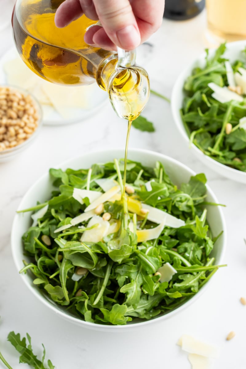 pouring oil onto insalata romantica