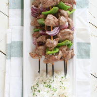 lamb souvlaki with rice on a white platter