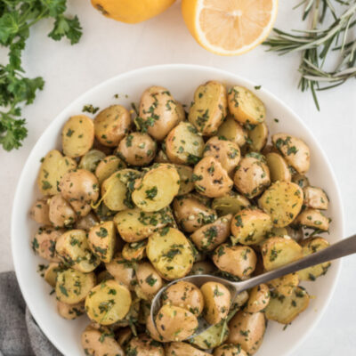 potatoes in bowl tossed with herbs