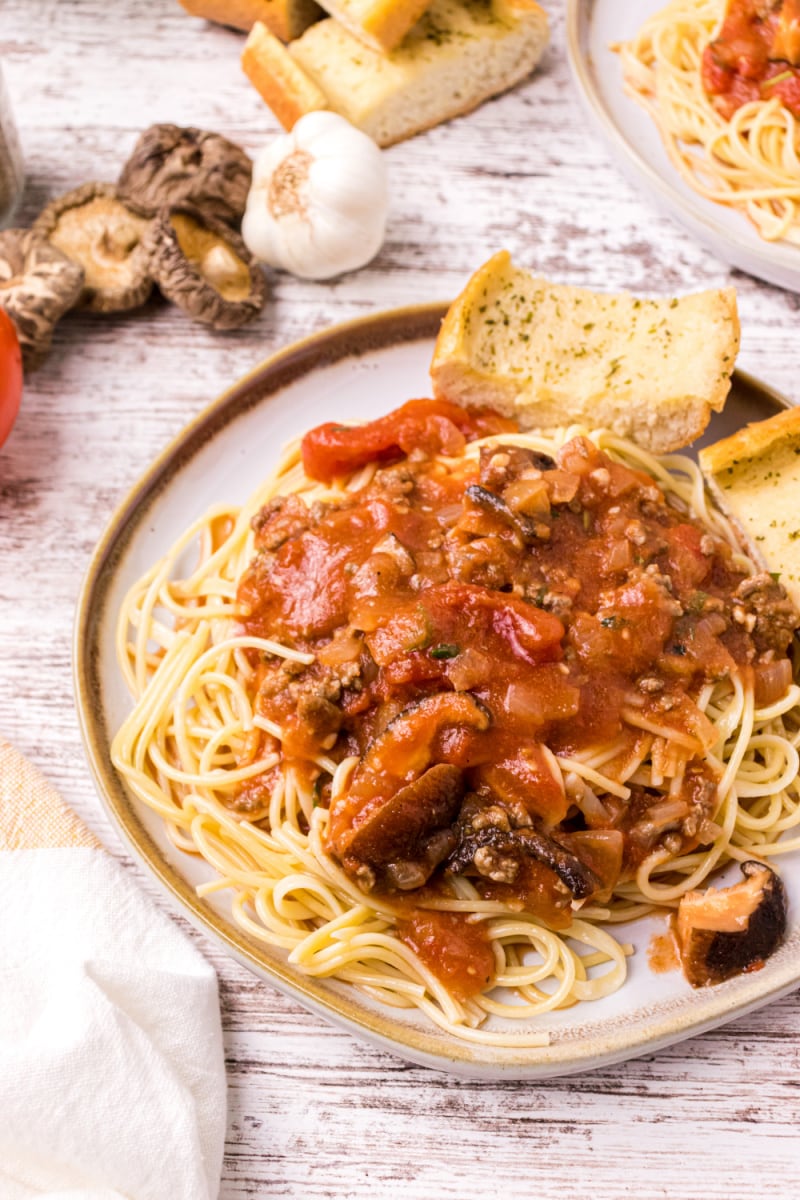 spaghetti with sauce and garlic bread on plate