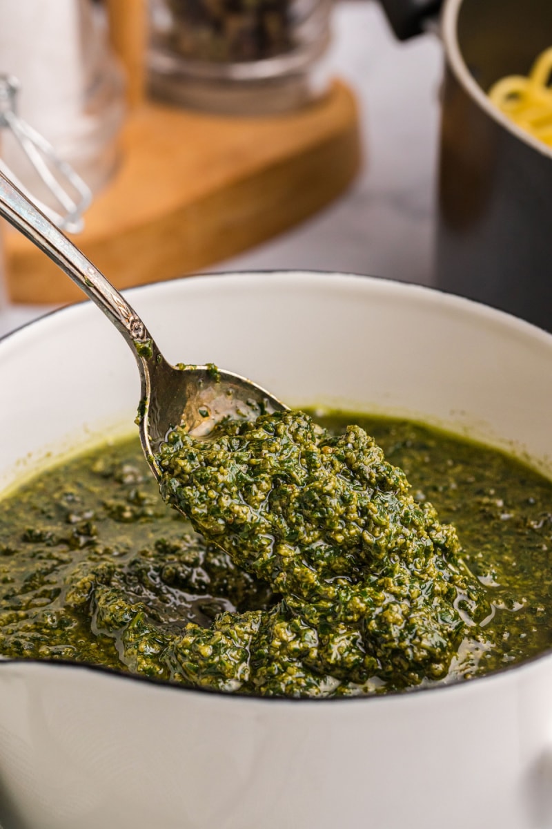 spooning pesto sauce out of bowl