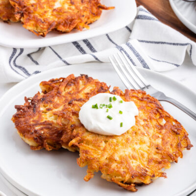 potato latkes on a plate with sour cream