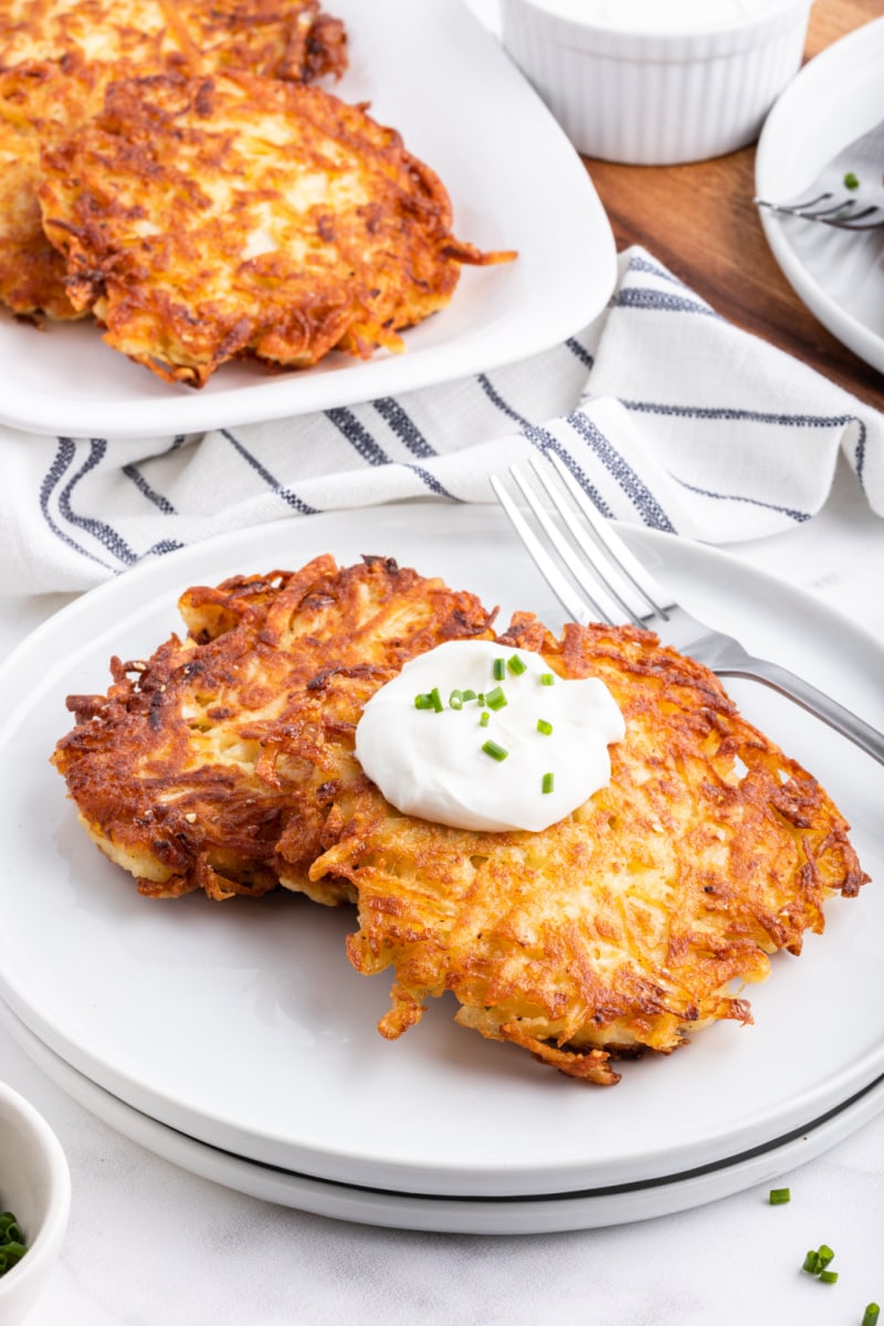 potato latkes on a plate with sour cream