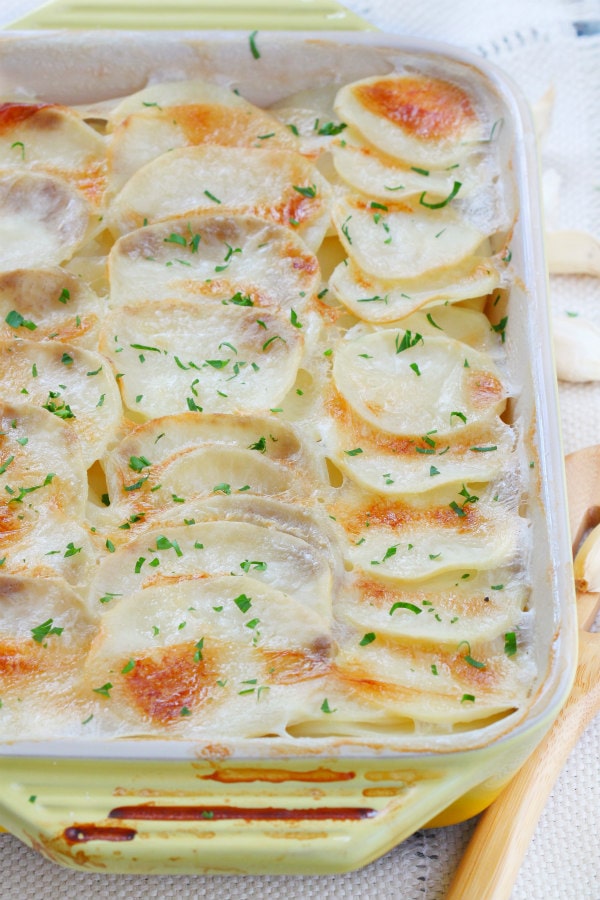 Scalloped Garlic Potatoes recipe from RecipeGirl.com #scalloped #garlic #potatoes #recipe #RecipeGirl Scalloped Garlic Potatoes in a casserole dish