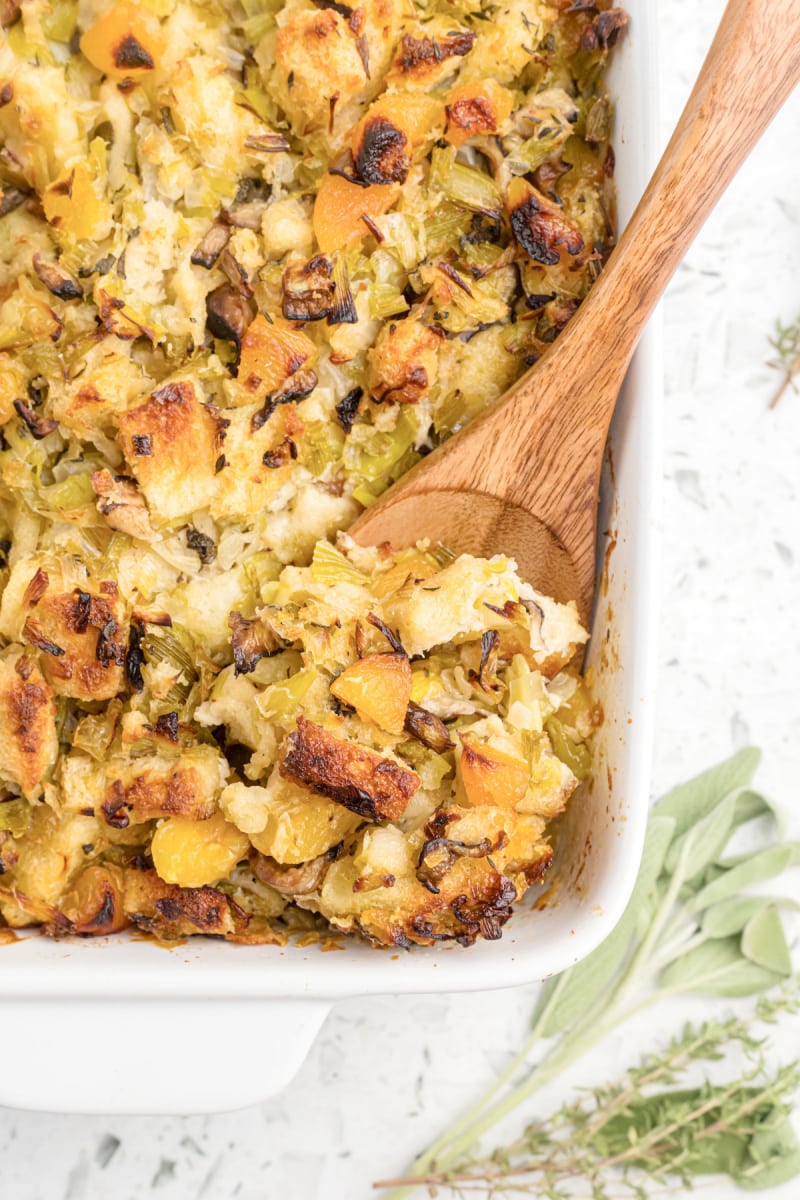 casserole dish of shiitake mushroom stuffing with wooden spoon