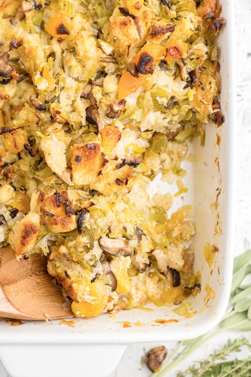 casserole dish of stuffing with scoop taken out of it