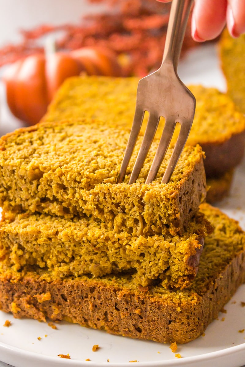 fork poking into slices of pumpkin banana bread