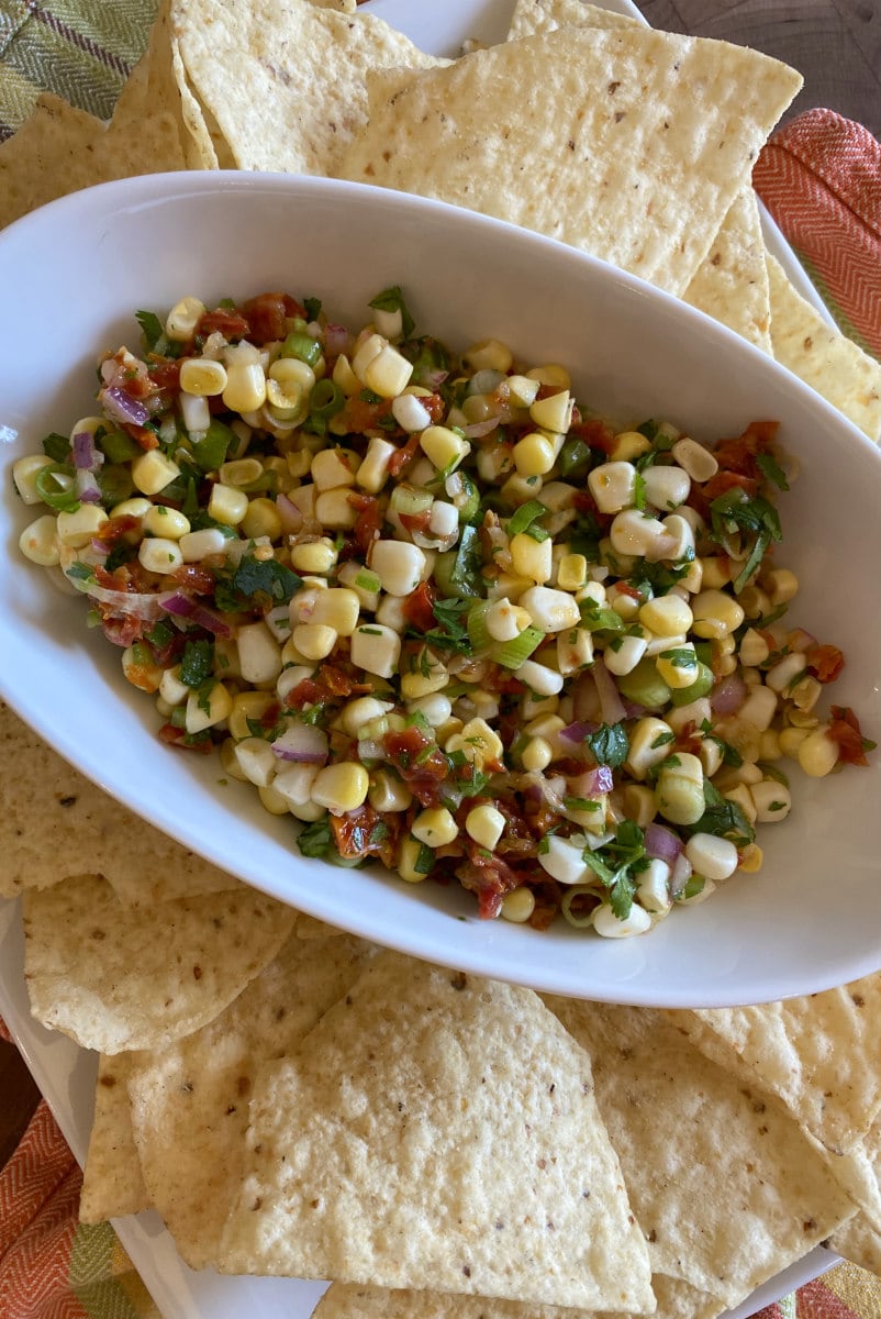 sundried tomato salsa in white bowl with chips surrounding