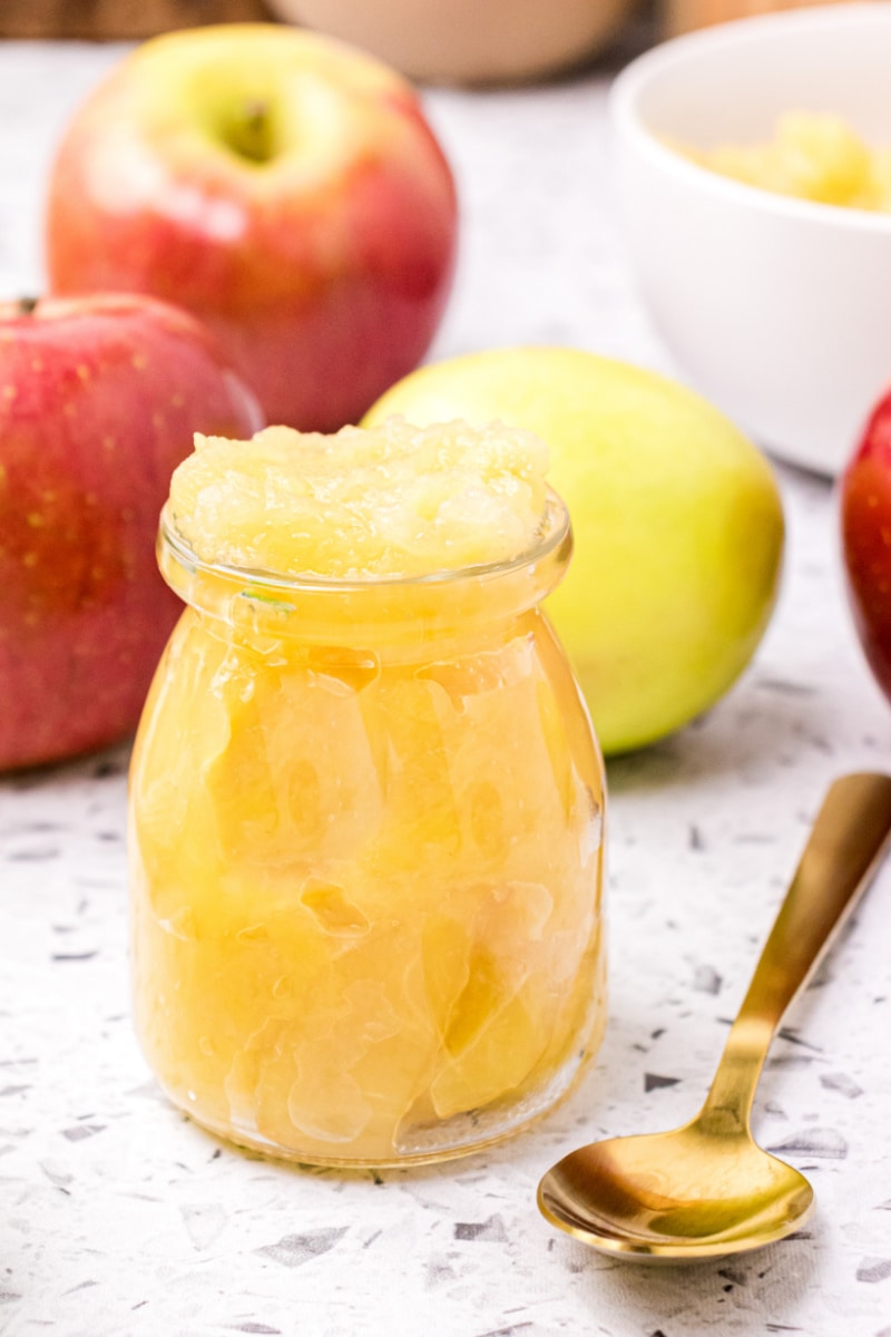 jar of applesauce with fresh apples and a spoon