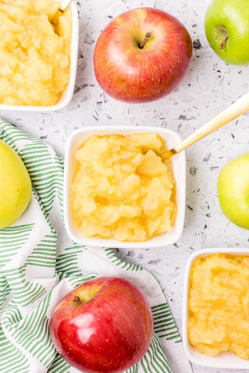 square bowls of apple sauce with fresh apples