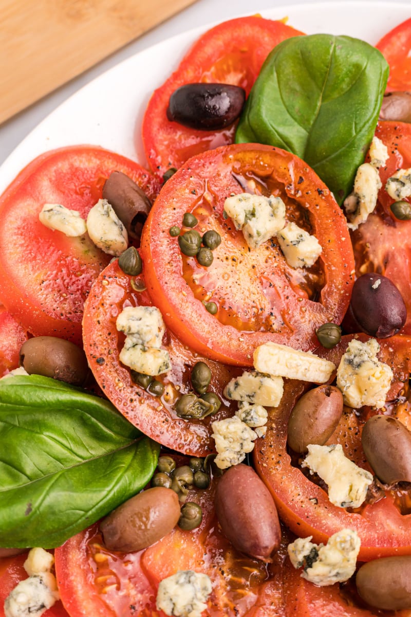 close up sliced tomatoes with blue cheese and basil