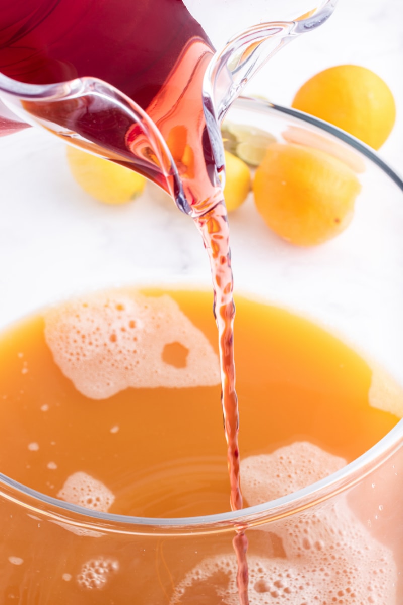 pouring cranberry juice into punch bowl