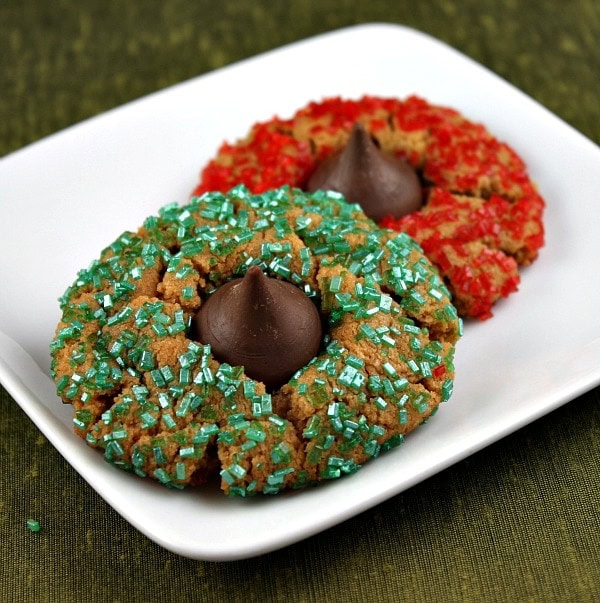 two holiday kiss cookies on a white plate