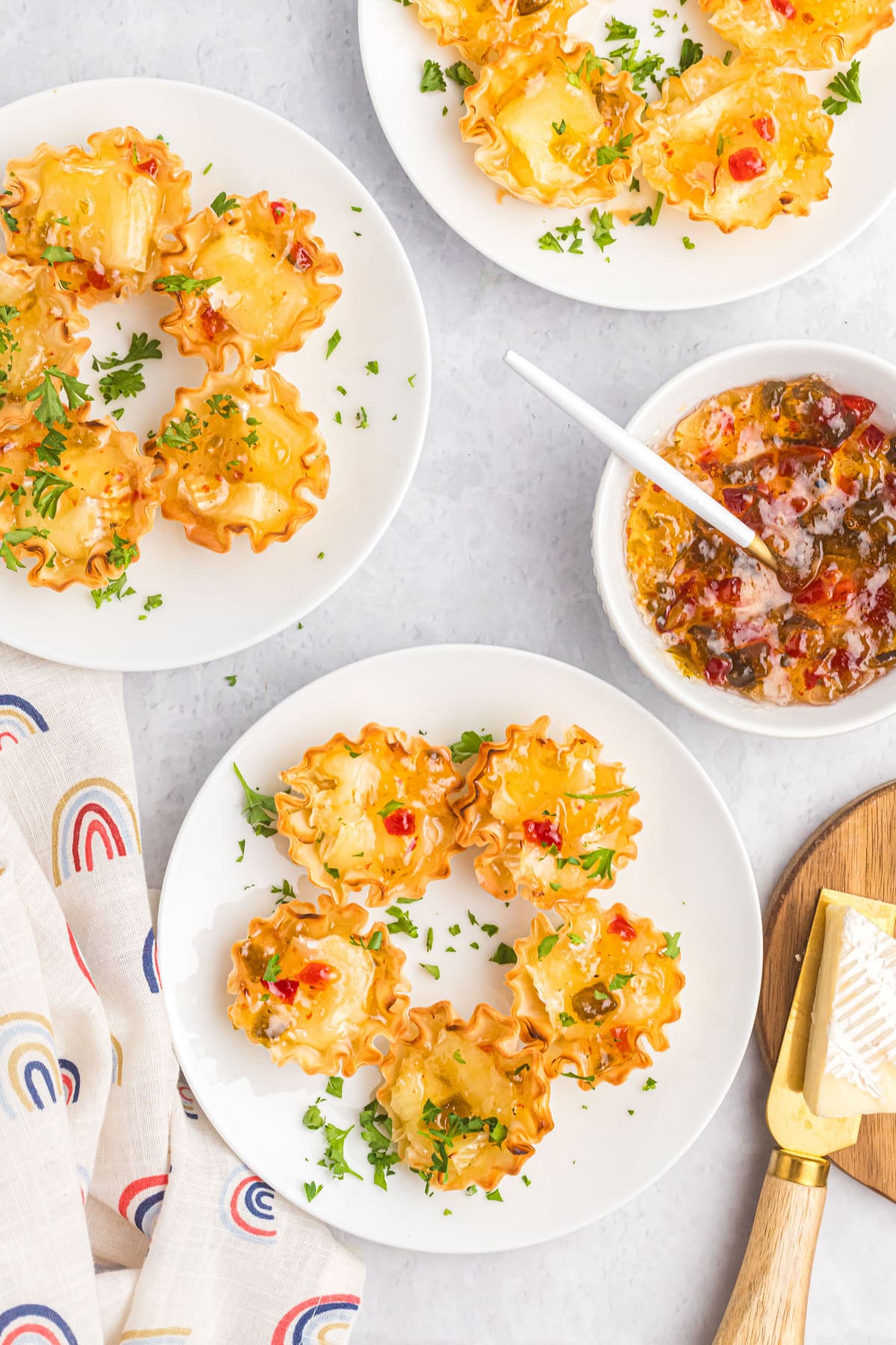 plates of hot brie kisses appetizers and a bowl of hot pepper jelly