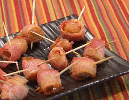 Bacon Wrapped Water Chestnuts on a black platter with a striped placemat