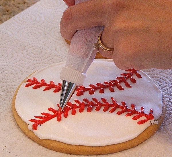 How to Make Baseball Cookies : adding red stitching with royal icing