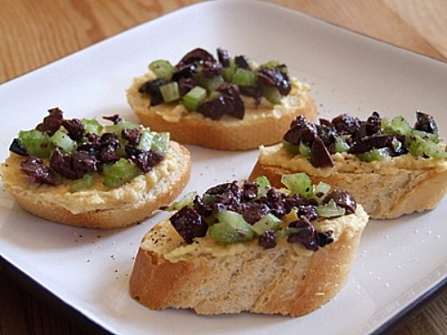 four greek crostini on a white plate