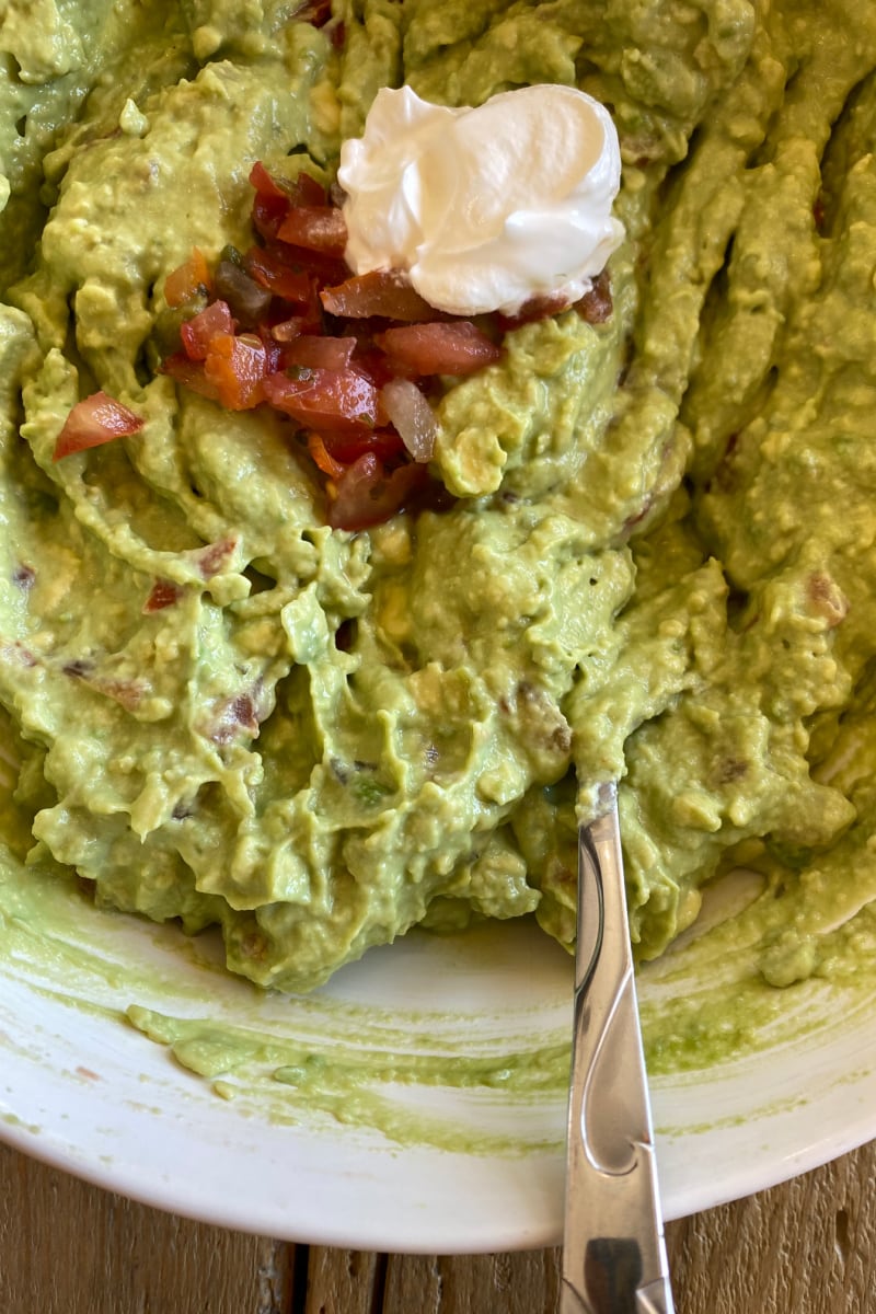 making guacamole in white bowl