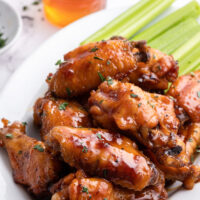 honey glazed chicken wings on platter with celery