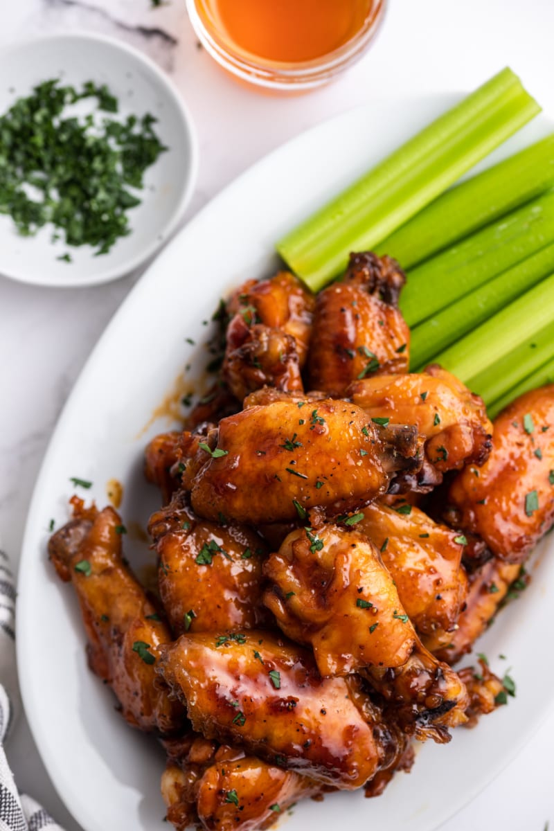 honey glazed chicken wings on a platter with celery