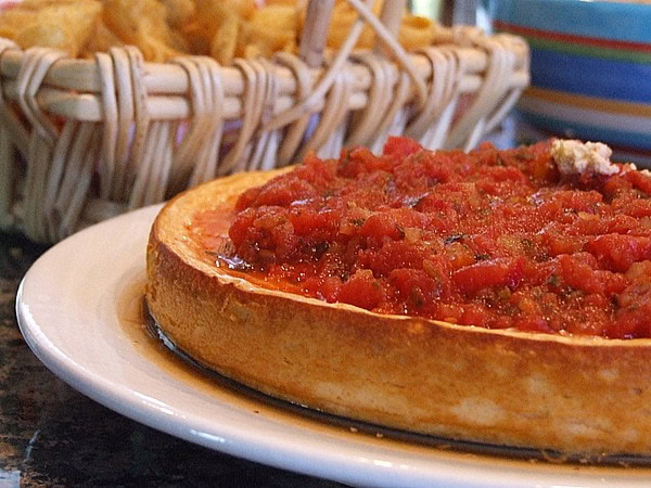 Mexican Cheesecake Dip mexican cheesecake dip on a plate with basket of chips