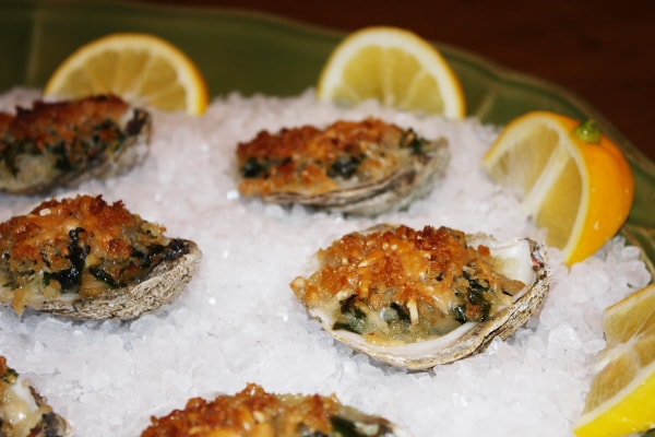 oysters rockefeller on ice with lemon wedges