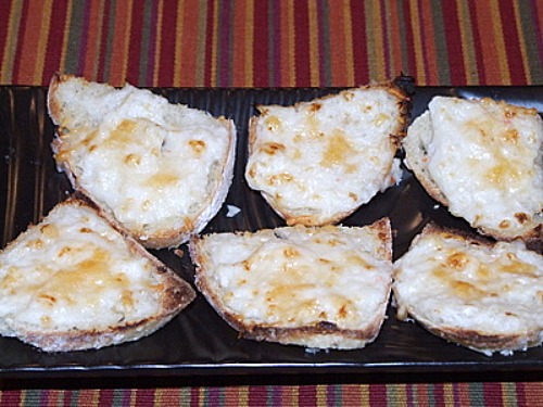 six parmesan crab bites on a black platter