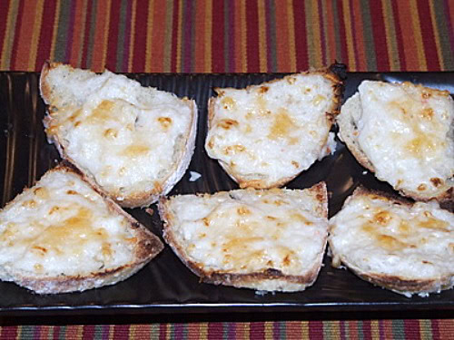 six parmesan crab bites on a black platter