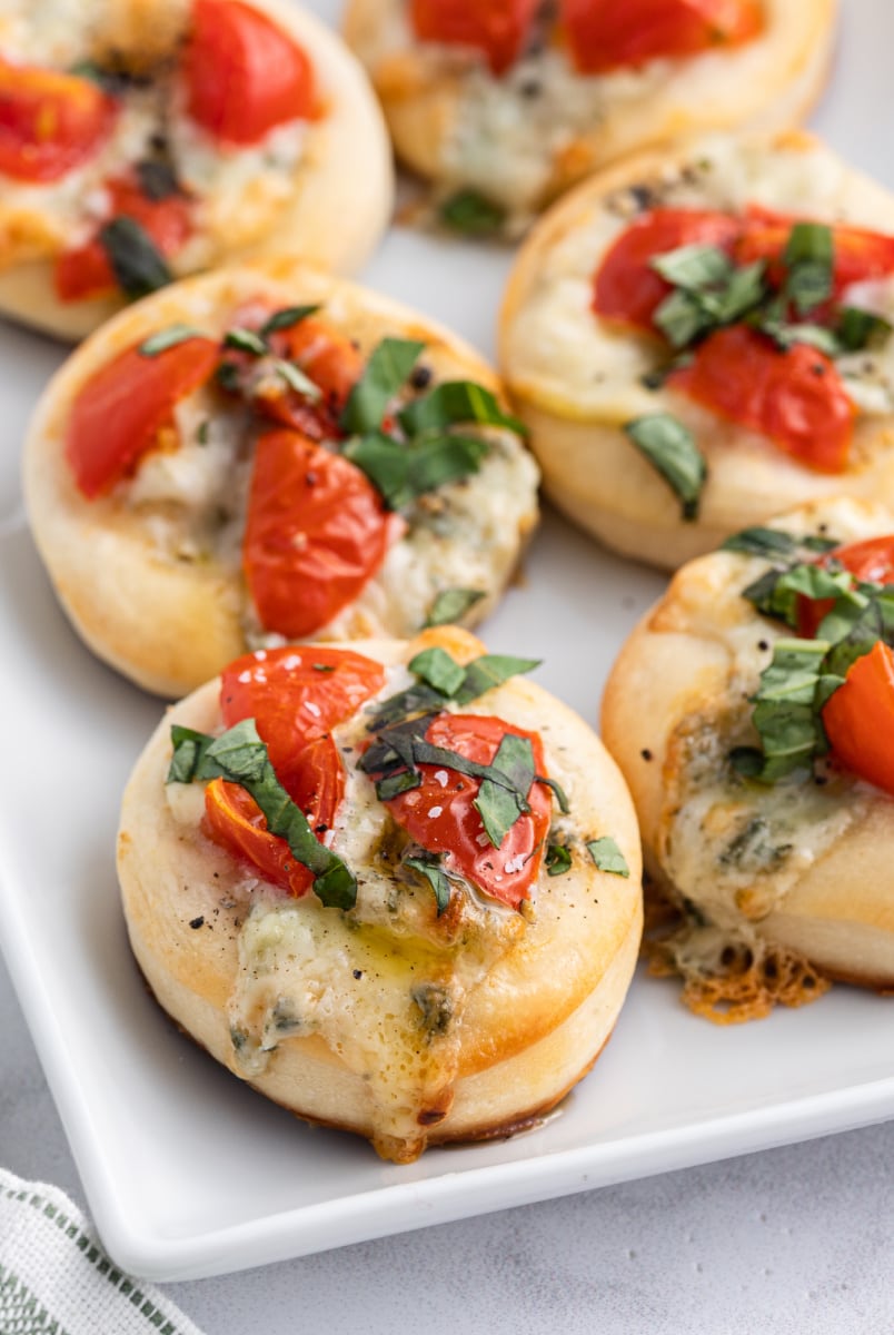 pizzette with gorgonzola tomato and basil on a platter