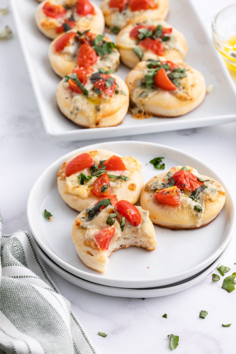 pizzette appetizers on a serving plate with platter in background