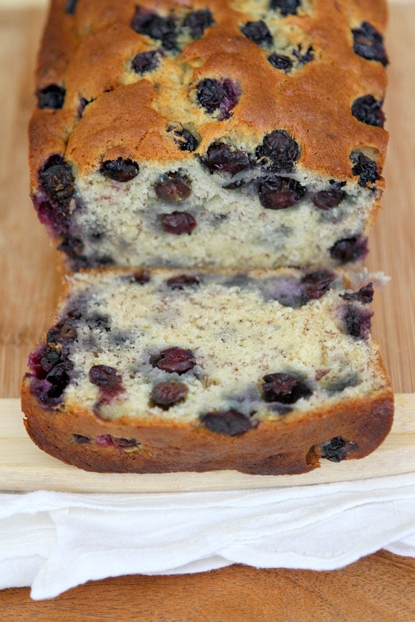 Banana Blueberry Bread loaf on a cutting board, cut open to see the inside